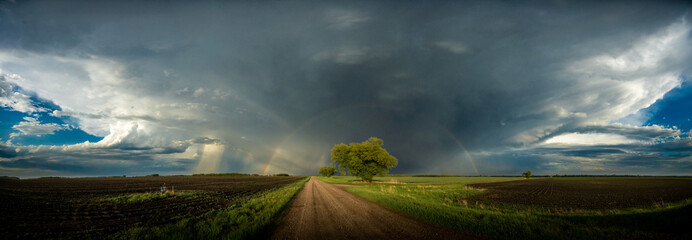 Rainbow over a country road after a summer storm