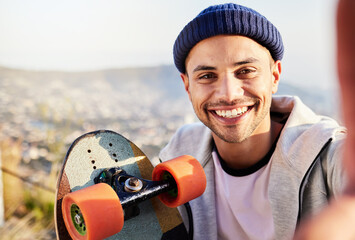 Portrait, selfie and view with a skater man in nature, taking a picture while outdoor for a skate. Summer, skateboard or photograph with a happy male outside in the mountains for recreation skating - obrazy, fototapety, plakaty