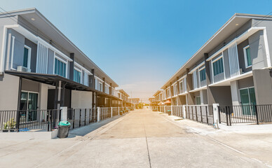 Fototapeta na wymiar The rows of new townhouses, view of the houses with paved roads in the middle , the architectural design of the exterior, The concept for Sale, Rent, Housing, and Real Estate
