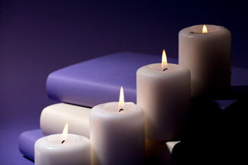 Obraz na płótnie Canvas candles and books with purple background