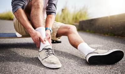 Fitness, athlete and man with ankle injury, pain or accident while skateboarding in the street. Sports, exercise and male skateboarder with muscle sprain, medical emergency or injured leg in the road © Malik E/peopleimages.com