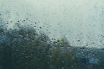 Drops on glass after rain. Autumn weather outside window. Rain outside window.