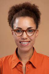 Vertical portrait of smiling African American woman in glasses smiling to camera