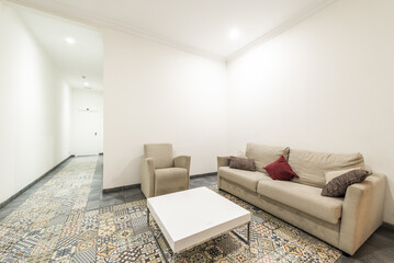 Apartment with hydraulic stoneware floors, a three-seater sofa and an armchair with a white wooden coffee table and a long corridor