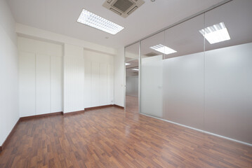 Empty office with technical ceilings, white walls with friezes and tempered glass separating wall...