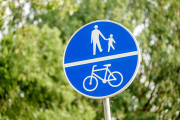 Path for pedestrians shared with a bike lane, cycle lane blue Polish traffic sign on the street,...