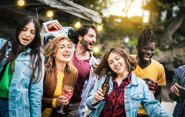 Multicultural friends group having fun out side cheering with drinks and beer bottles - Millenial people enjoying party at private villa together - Youth life style concept on bulb string light filter