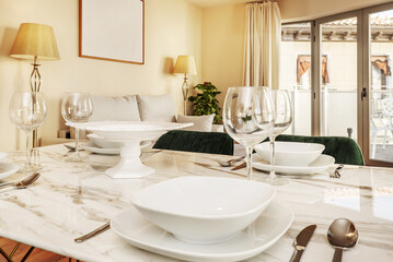 A white marble dining table with crystal stemware and white crockery