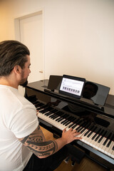 Handsome young man learning to play the piano