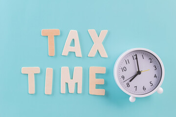 Tax fill concept, "TAX TIME" word with clock on blue or green backgound color