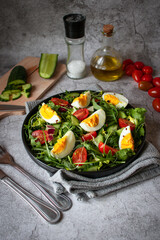 Salad with egg, arugula, tomatoes. On a concrete background. Vegetarian