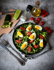 Salad with egg, arugula, tomatoes. On a concrete background. Vegetarian
