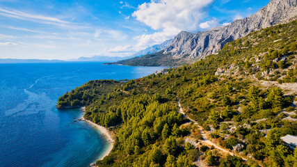 Fototapeta na wymiar A drone captured the stunning aerial view of Croatia's coastal area, which features crystal-clear blue water and lush forests on land.