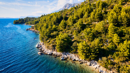 Fototapeta premium The stunning beauty of Croatia's rocks and forests is captured in this breathtaking aerial view. Take in the turquoise waters and beach from above, and add this travel image to your collection of unfo
