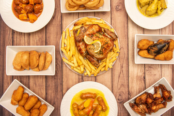 Set of typical Spanish food tapas dishes with known recipes, Sunday roast chicken, croquettes, empanadillas, tigres mussels, chistorra with potatoes