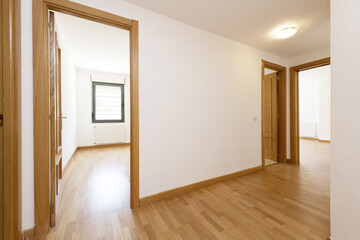 Distributor corridor of a house with floating oak wood floors and carpentry for doors, moldings and...