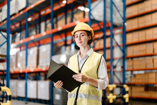 smart woman worker wearing working suite dress and safety helmet at cargo for stack item for shipping.female worker checking the store factory. industry factory warehouse. Inspection quality control.