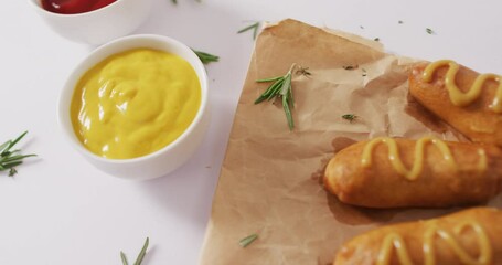 Video of corn dogs with dips on a white surface
