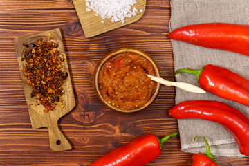 Ajvar from sweet peppers, eggplant, tomatoes, garlic and onions with spices wooden table. Balkan food. Selective focus