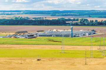 Fototapeta na wymiar aerial view of rows of agro farms with silos and agro-industrial livestock complex