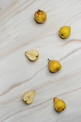 Some ripe pears on a white marble surface with brown veins