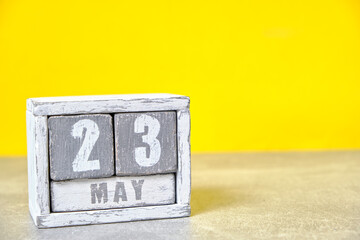 May 23 calendar made wooden cubes yellow background.With an empty space for your text.