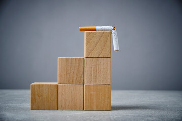 There broken cigarette at top of wooden cube ladder.Concept, World no tobacco Day.