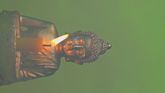 Candle holder with Buddha image. Vertical