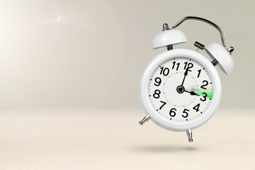 Change time. Summer time concept, on a wooden background. A white alarm clock with a minute hand...