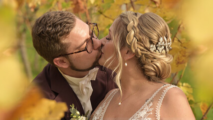 Bride and groom kissing on wedding day in nature.