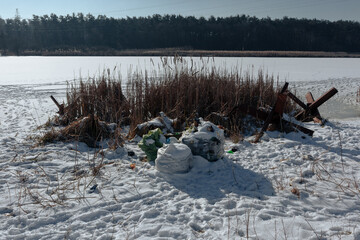 Garbage bags on the shore of a frozen lake in winter