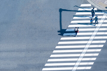 Human life in Social distance. Aerial top view with blur man with smartphone and group of people walking at pedestrian crosswalk on grey pavement street road with empty space.