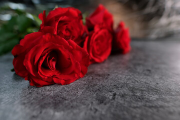 Naklejka premium bouquet of red, pink roses with copy space for designer, flowers for professional holiday on grey background, concept of mother's, Valentine's day, birthday, day of mourning, selective focus