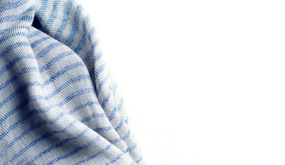 Background with draped blue gray cotton fabric, napkin, striped tablecloth or scarf on white surface, copy space	
