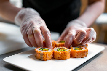 professional chef's hands making sushi and rolls in a restaurant kitchen