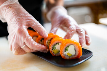 professional chef's hands making sushi and rolls in a restaurant kitchen
