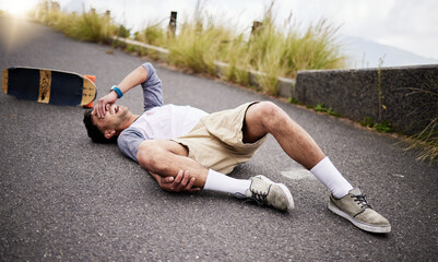 Accident, fall and knee injury with a skater man on the ground, lying down in pain after falling...