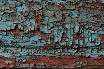 Wooden surface. Cracked paint. Green and burgundy colors. Background. Texture. Layer. Copy space