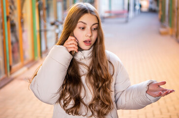 amazed teen girl having phone call in the street. teen girl having phone call outdoor.