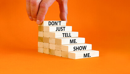 Tell or show symbol. Concept words Do not just tell me, show me on wooden blocks. Beautiful orange...