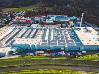 Aerial view of a large factory in the countryside trying to be more eco friendly with solar panels on the roof