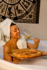 portrait of an attractive dark-haired girl with a towel on her head .the girl sits in the bath...