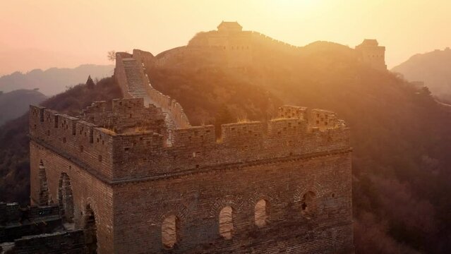 Aerial shot of the Great Wall of China at sunset on a hazy day.