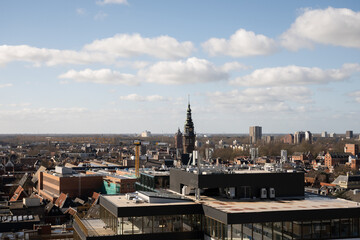 Obraz premium Groningen cityscape skyline with cathedral spire breaking the horizon on a sunny clear day. The Sint Jozefkathedraal gothic religious architecture is prominent against modern buildings