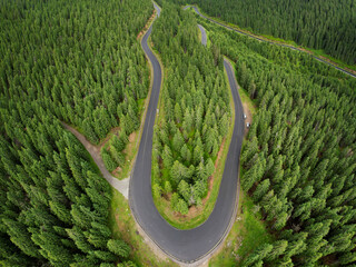 Aerial drone panorama above the wild coniferous forests of Sureanu Mountains. Transalpina asphalt...