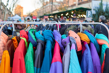 Second hand and sustainable shopping. Retro second hand coats hanging on a display rack at a flea...