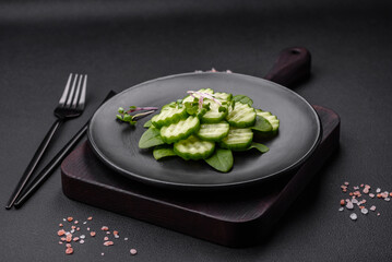Delicious healthy raw cucumber sliced ??on a black ceramic plate