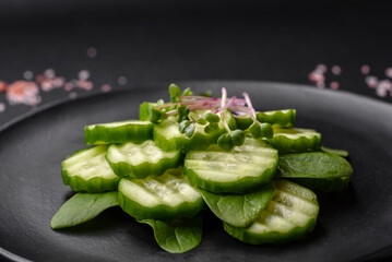 Delicious healthy raw cucumber sliced ??on a black ceramic plate