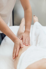 Fototapeta na wymiar Professional masseur make remedial body massage to a Woman's body lying face down on massage table in spa salon
