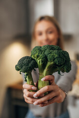 Woman holds broccoli in her hands